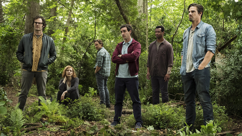 Le Losers Club adulte debout dans une forêt 