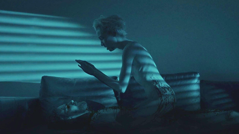 Sarah s'accroupit sur un corps dans Come True (2021)