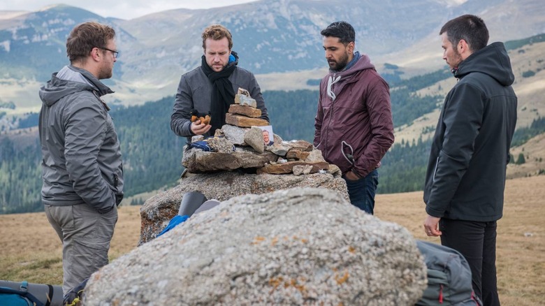 Luke, Phil, Hutch et Dom empilent des pierres dans The Ritual