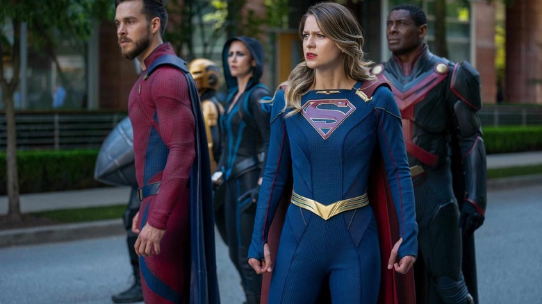 Supergirl debout avec ses camarades de super-héros 