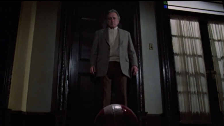 John regarde une boule rouge sur le sol 
