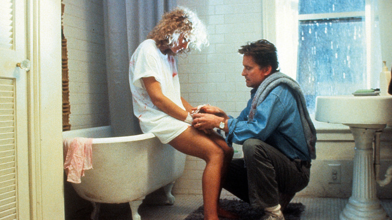Dan bandant les poignets d'Alex dans la salle de bain dans Fatal Attraction