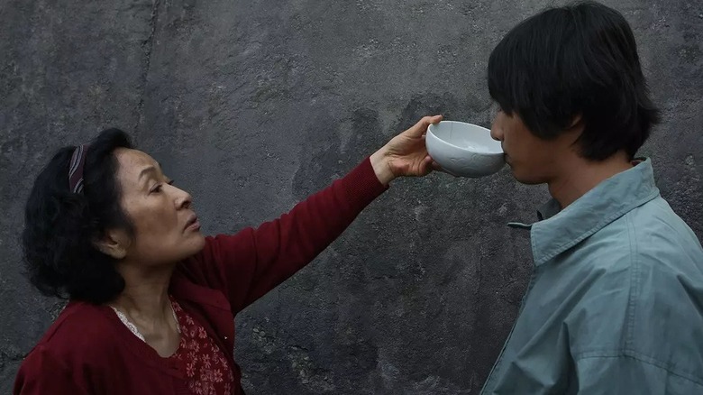 Mère donnant à Do-joon un verre dans un bol 