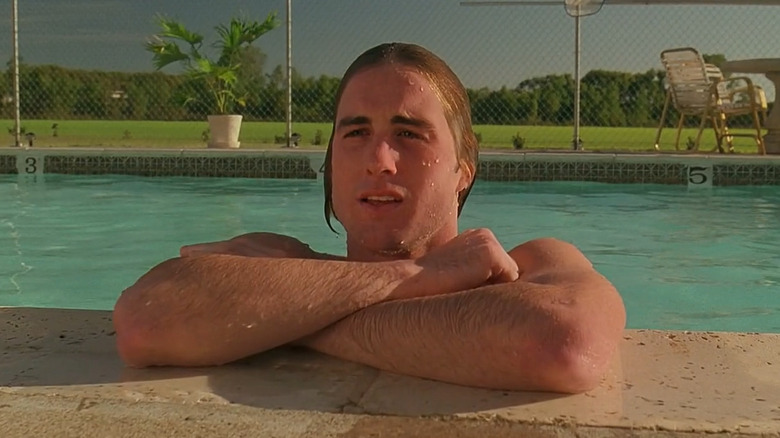 Anthony dans une piscine, adossé au bord, 
