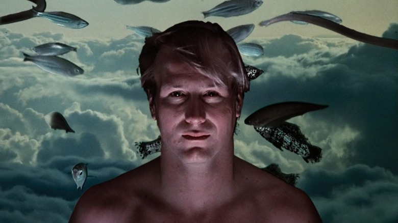 Eddie Jessup avec du poisson derrière lui dans Altered States