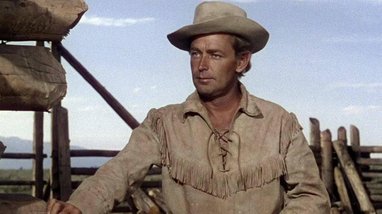 Shane pose la main sur une clôture dans Shane (1953)