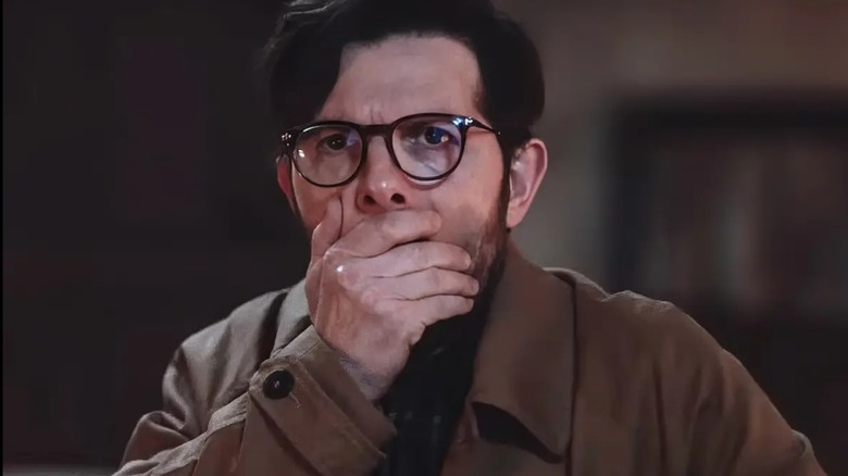 Ohm Bauman se couvre la bouche en Hokum