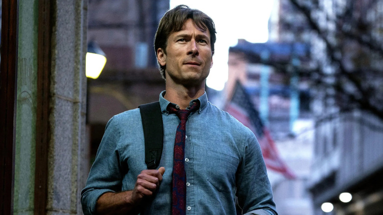 Becket dans la rue en train de regarder quelque chose dans How to Make a Killing