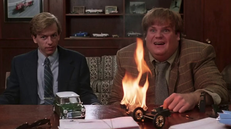 Tommy et Richard tentent de lancer une vente pendant qu'une voiture miniature brûle sur le bureau dans Tommy Boy
