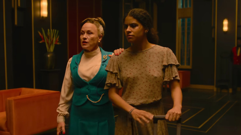 Lily Woodhouse guide Asia Reaves dans un hall d'entrée dans They Will Kill You
