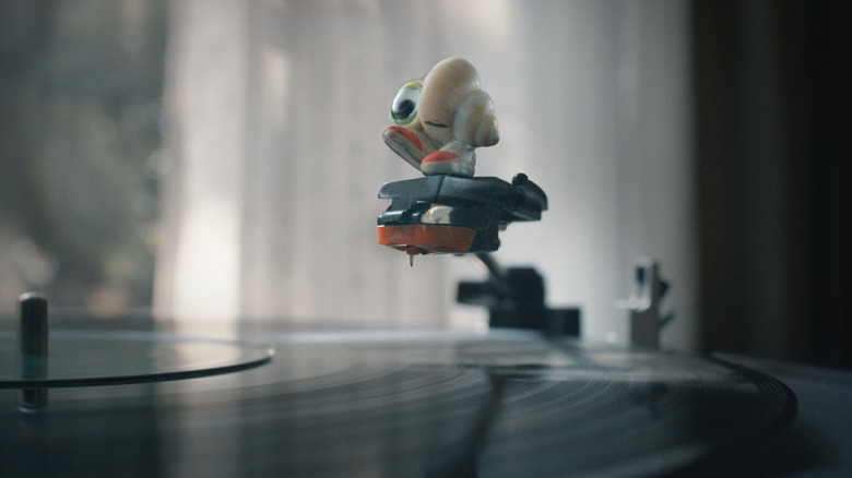 Marcel joue avec un tourne-disque dans Marcel the Shell with Shoes On (2022)