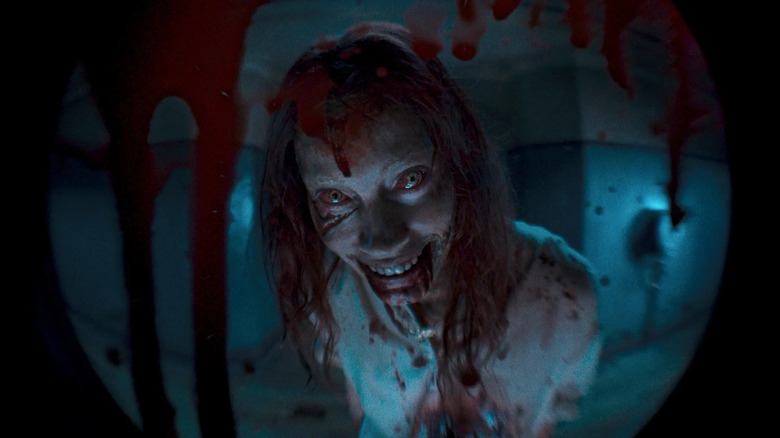 Ellie possédée attendant devant l'appartement dans Evil Dead Rise (2023)