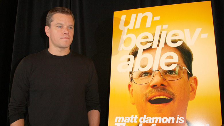 Matt Damon debout à côté d'une affiche pour 
