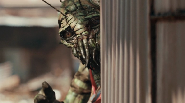 Alien scrutant derrière le mur