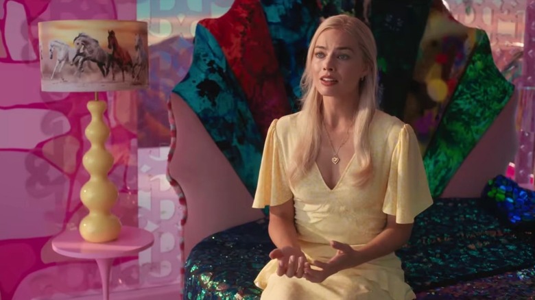 Barbie triste assise sur son lit en robe jaune