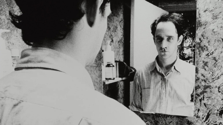 Max regarde dans le miroir de la salle de bain 
