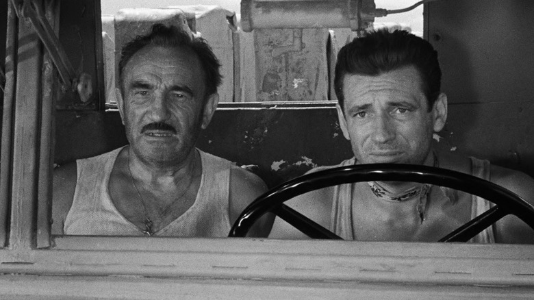 Mario et Jo sur le siège avant du camion, l'air inquiets dans Le Salaire de la Peur