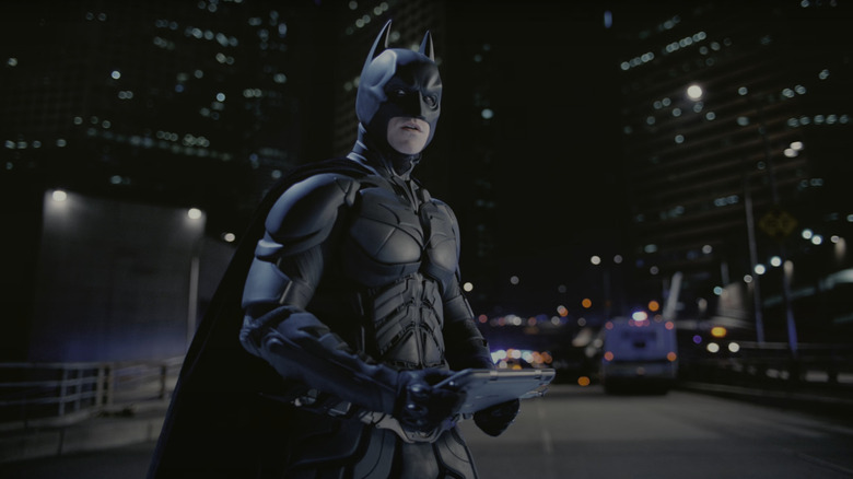 Batman debout sur une route dans sa tenue dans The Dark Knight Rises