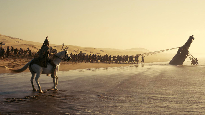 Soldats troyens tirant le cheval du sable dans L'Odyssée (2026)