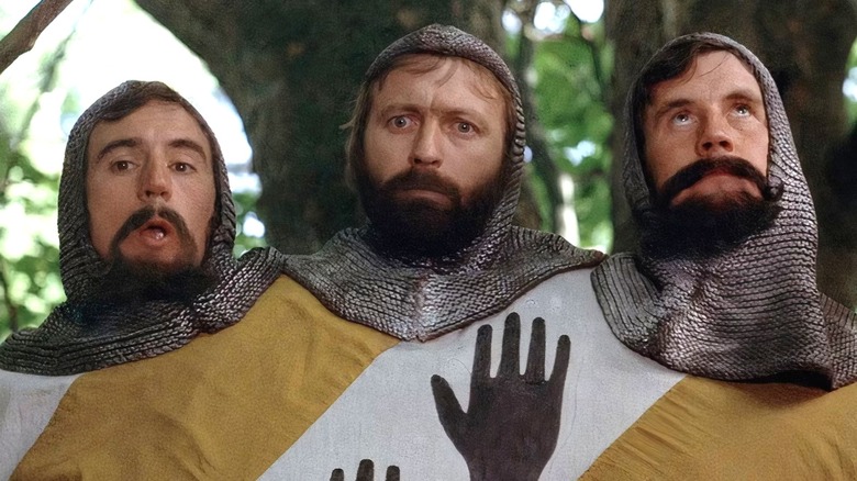 Le chevalier à trois têtes debout devant des arbres 