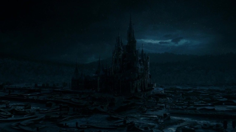 Un plan large et sombre du Château de la Bête dans La Belle et la Bête (2017)