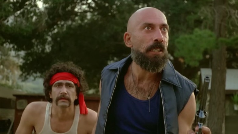 Cutter et un homme de main courent vers la caméra, armes au poing, dans The Aftermath