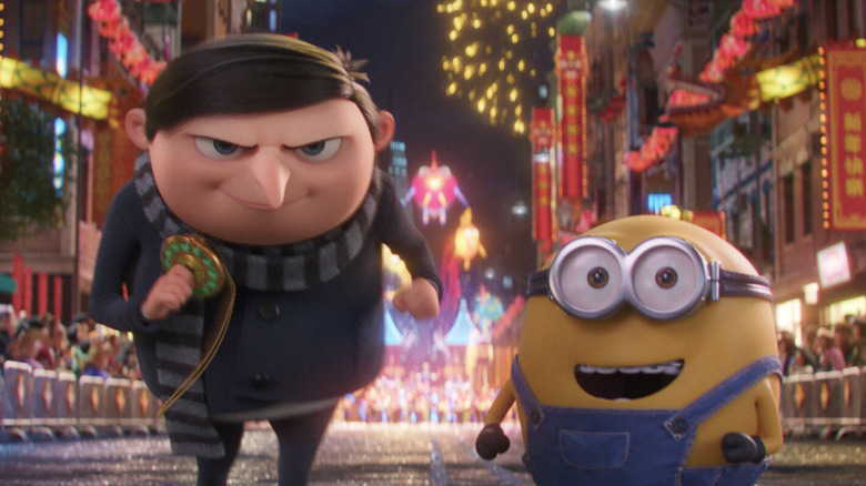 Gru faisant la course avec une amulette et un ami Minion dans Minions : The Rise of Gru (2022)