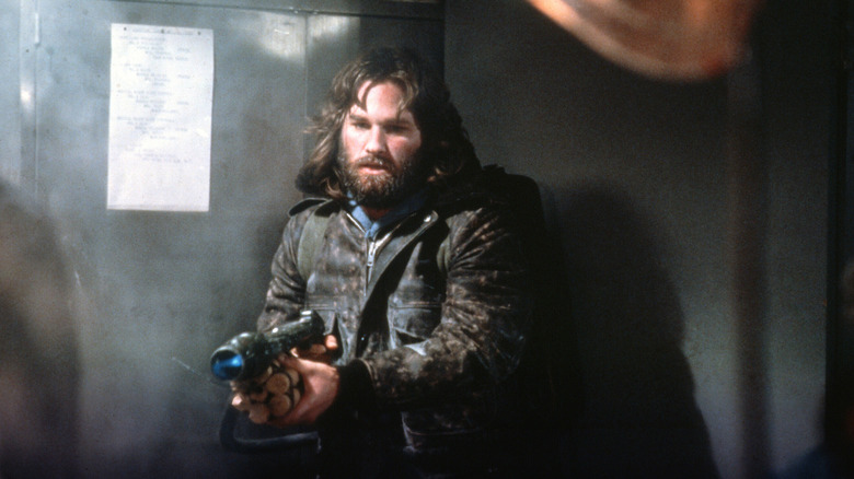 Kurt Russell visant un lance-flammes