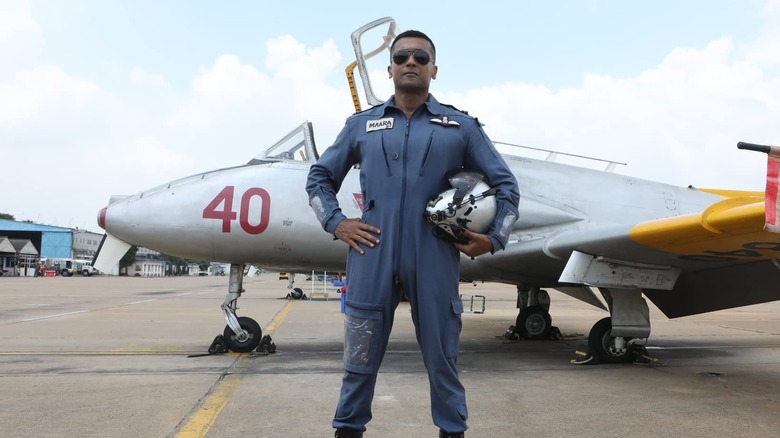Nedumaaran Rajangam debout à côté d'un de ses jets dans Soorarai Pottru (2020)
