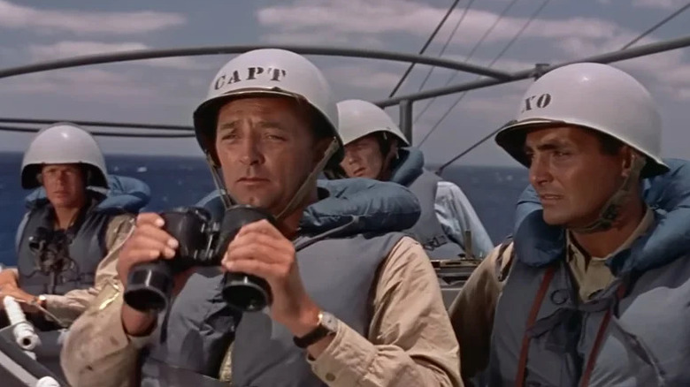 Le capitaine Murrell tient des jumelles pendant que ses hommes regardent dans The Enemy Below