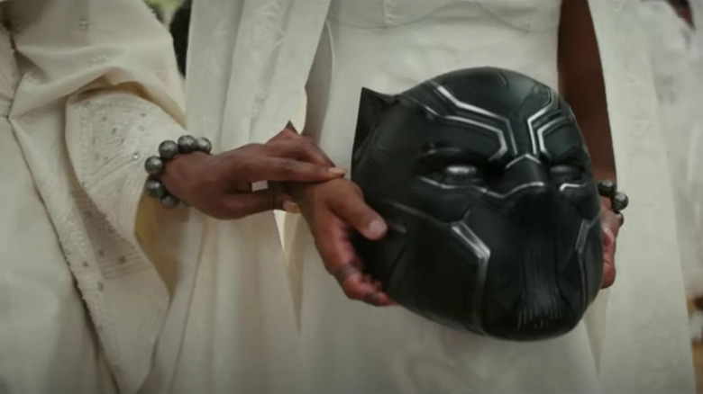 Mains tenant le masque Black Panther