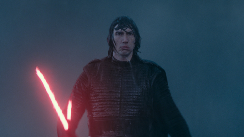 Un Kylo Ren très mouillé marchant sous la pluie avec son sabre laser rouge allumé dans Star Wars : Épisode IX – L'Ascension de Skywalker (2019)