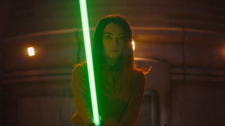 Sabine Wren brandissant un sabre laser vert la nuit dans Star Wars : Ahsoka (2023)