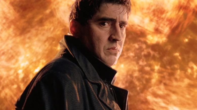 Otto Octavius ​​regarde tristement Peter Parker alors que le feu menace derrière lui à la fin de Spider-Man 2 (2004)