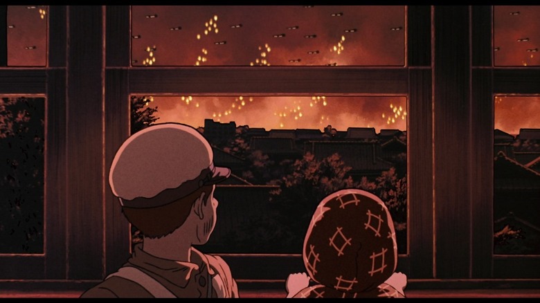 Seita et Setsuko regardent par la fenêtre les raids aériens dans Le Tombeau des lucioles