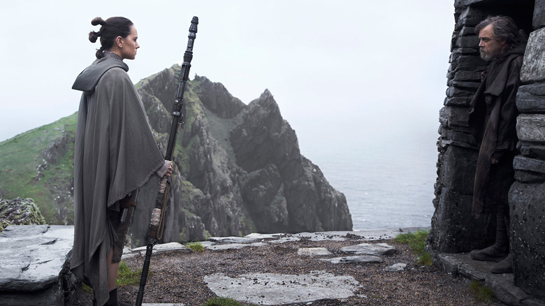 Rey s'approchant de Luke Skywalker dans sa grotte dans Star Wars : Les Derniers Jedi (2017)