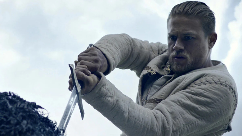 Arthur retire l'épée de la pierre dans King Arthur : Legend of the Sword (2017)