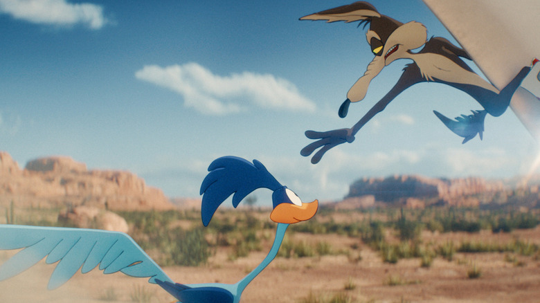 Montant une fusée, Wile E. Coyote tend la main vers le Road Runner dans le désert en 