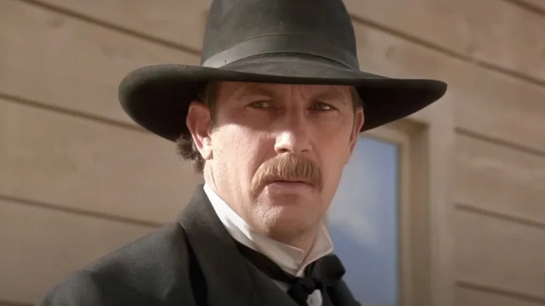Wyatt Earp a l'air surpris avec un chapeau noir dans Wyatt Earp