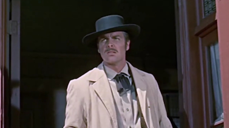 Jesse James portant un manteau blanc et un chapeau noir dans L'histoire vraie de Jesse James