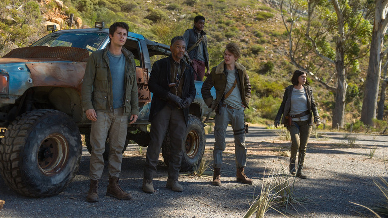Les personnages principaux de The Maze Runner : The Death Cure se tiennent à l'extérieur d'un grand camion patchwork (2028)