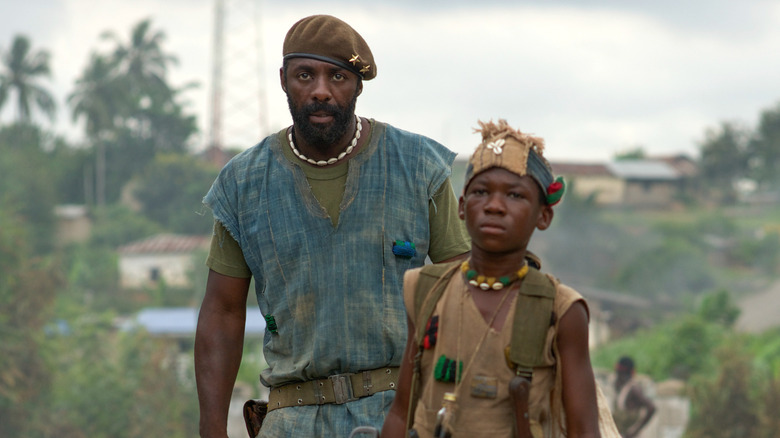 Commandant debout près d'Agu dans Beasts of No Nation