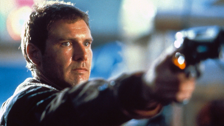 Rick Deckard pointe une arme de poing et grimace 