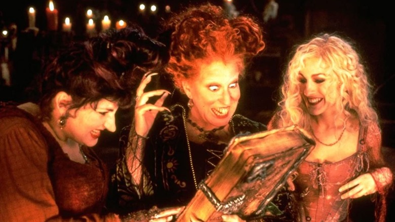 Mary, Winifred et Sarah Sanderson avec un livre de sorts