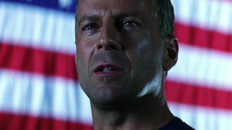 Harry S. Stamper debout devant le drapeau américain à Armageddon