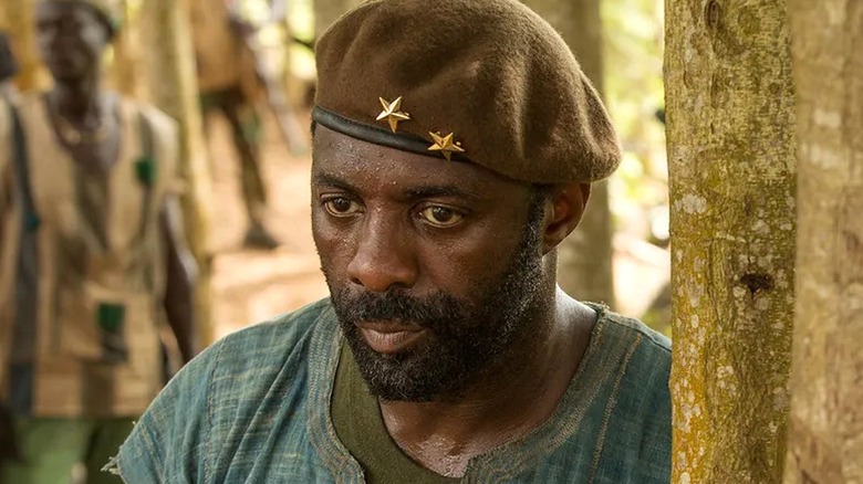 Commandant debout près d'un arbre en sueur dans Beasts of No Nation