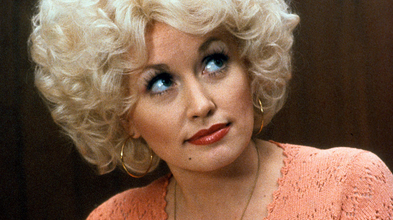 Doralee levant les yeux dans un pull orange de 9h à 17h.