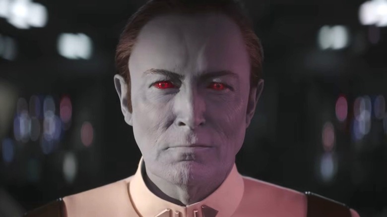 Le Grand Amiral Thrawn grimaçant sous la lumière rouge, vêtu d'un uniforme impérial blanc moulant, en