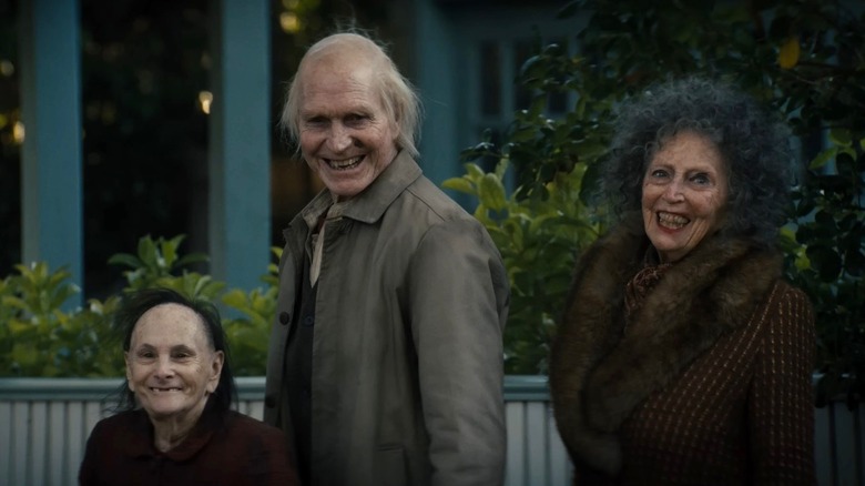 Trois personnes âgées souriant d'un air menaçant dans Insidious : Out of the Further