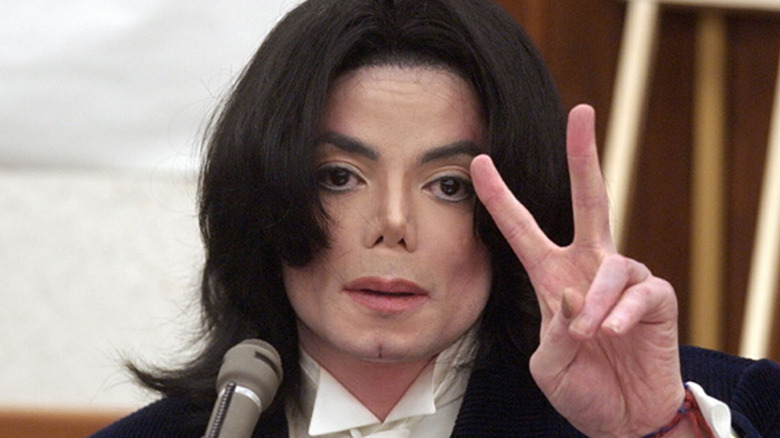 Michael Jackson brandit le signe de la paix devant le tribunal en 2002